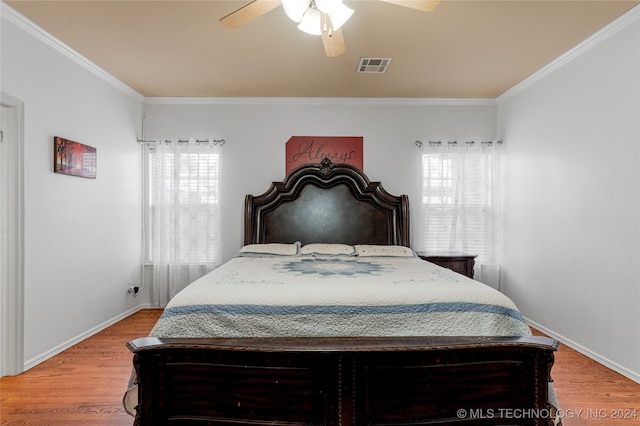 bedroom with multiple windows, wood-type flooring, and ceiling fan