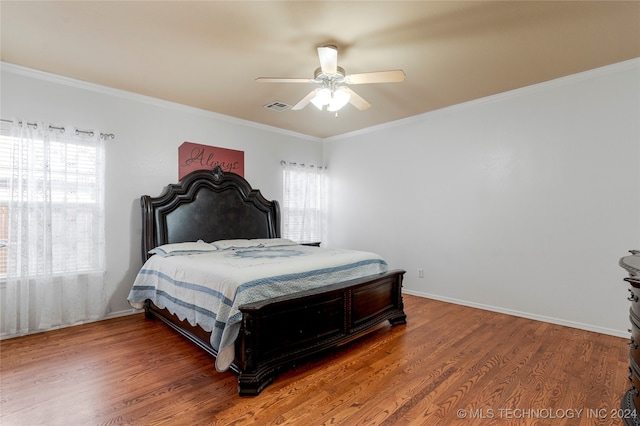 bedroom featuring multiple windows, wood-type flooring, and ceiling fan