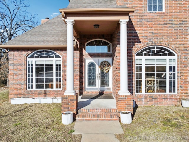 property entrance with a lawn and french doors