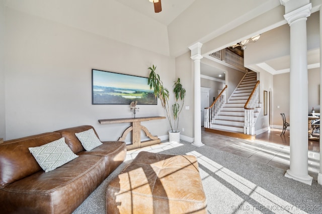 tiled living room with decorative columns, a high ceiling, and ceiling fan