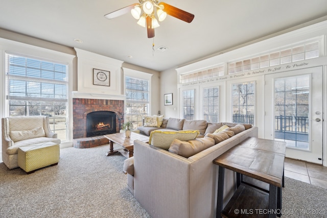 living room featuring a fireplace, tile patterned floors, and ceiling fan