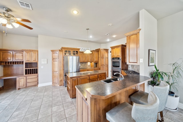 kitchen with sink, hanging light fixtures, backsplash, a kitchen bar, and kitchen peninsula