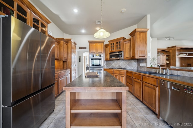 kitchen with sink, light tile patterned floors, a kitchen island, stainless steel appliances, and decorative backsplash