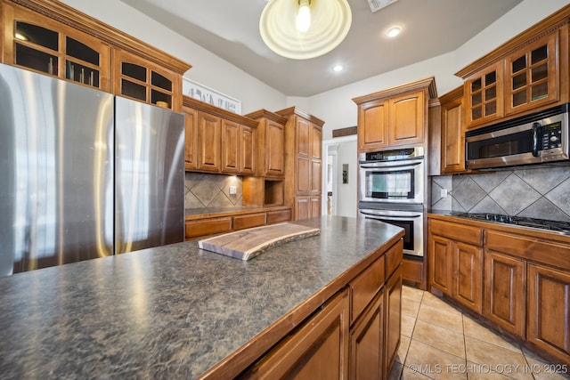 kitchen with light tile patterned floors, decorative backsplash, and appliances with stainless steel finishes