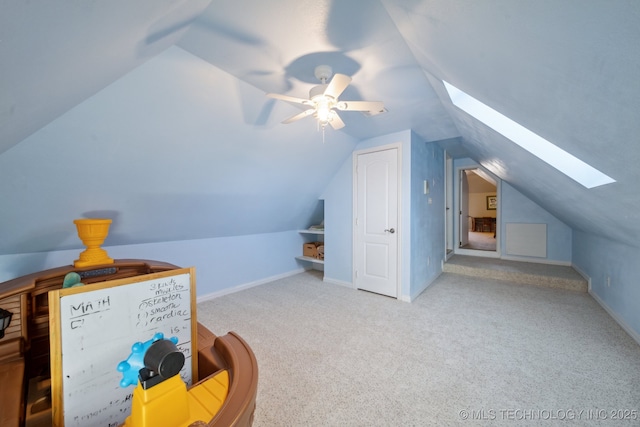 bonus room featuring ceiling fan, vaulted ceiling with skylight, and carpet flooring