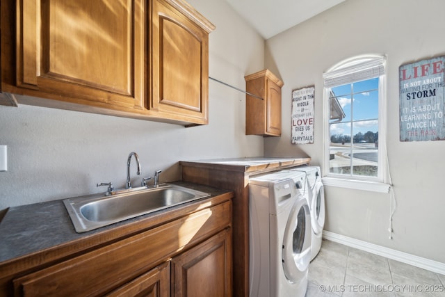 laundry area with separate washer and dryer, sink, light tile patterned floors, and cabinets