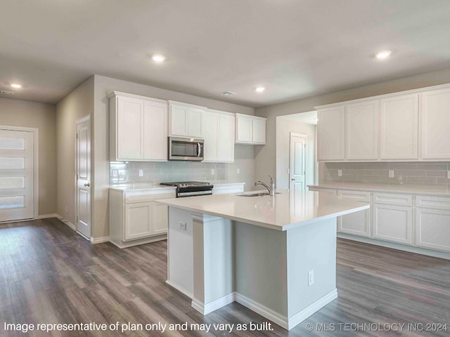 kitchen with dark hardwood / wood-style flooring, white cabinets, stainless steel appliances, and an island with sink