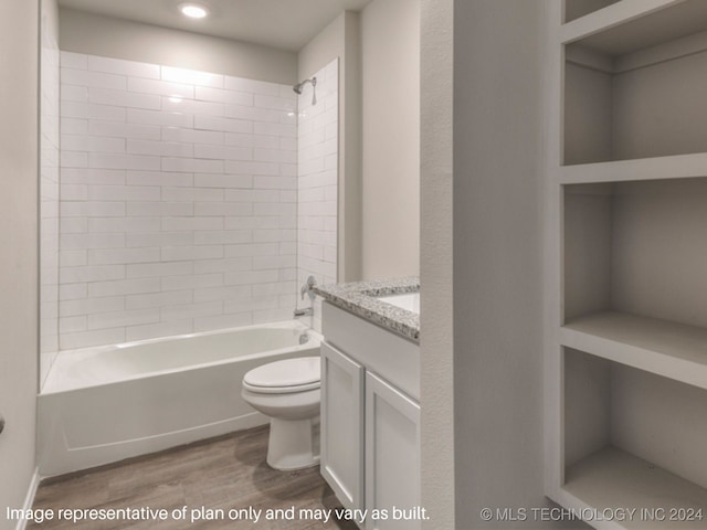 full bathroom with tiled shower / bath, vanity, hardwood / wood-style flooring, and toilet