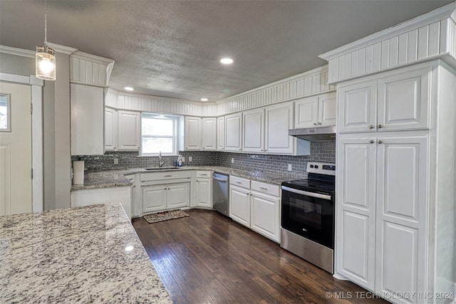 kitchen with appliances with stainless steel finishes, white cabinetry, light stone countertops, dark hardwood / wood-style floors, and decorative light fixtures