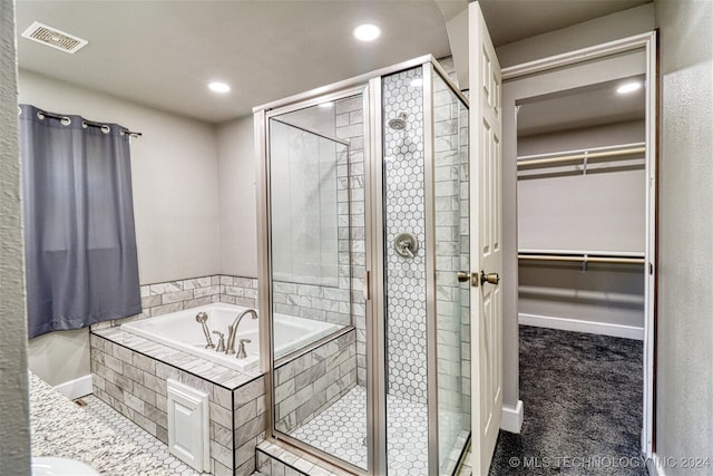 bathroom with vanity and shower with separate bathtub