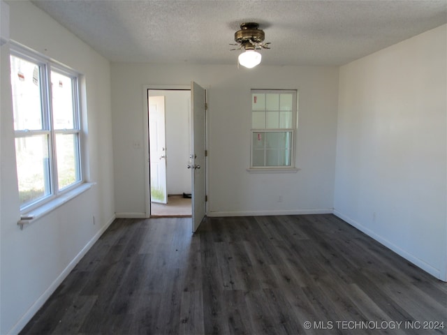 unfurnished room featuring ceiling fan, a textured ceiling, and dark hardwood / wood-style flooring