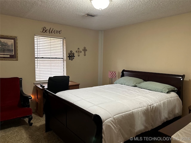 bedroom with a textured ceiling and carpet floors