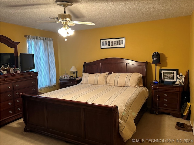 bedroom featuring a textured ceiling, light colored carpet, and ceiling fan