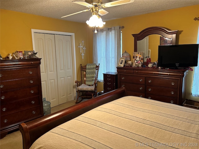 carpeted bedroom with a closet, a textured ceiling, and ceiling fan