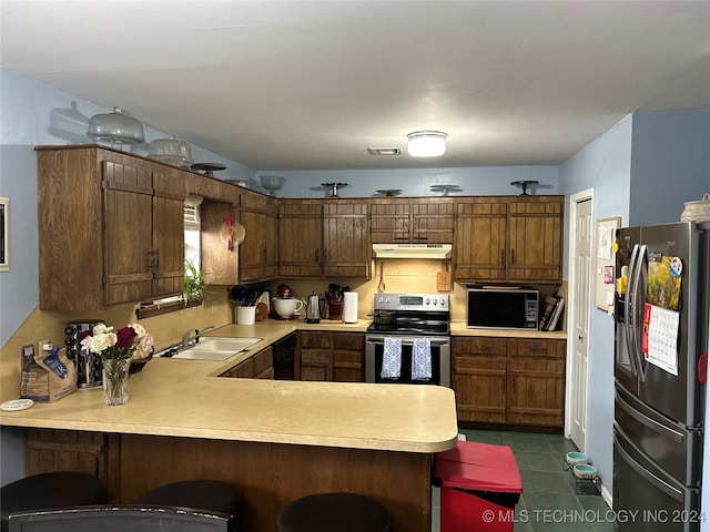 kitchen featuring a kitchen breakfast bar, sink, black appliances, and kitchen peninsula