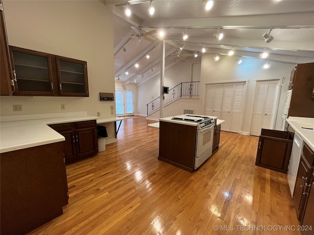 kitchen featuring a center island, light hardwood / wood-style floors, ceiling fan, white range with gas cooktop, and high vaulted ceiling