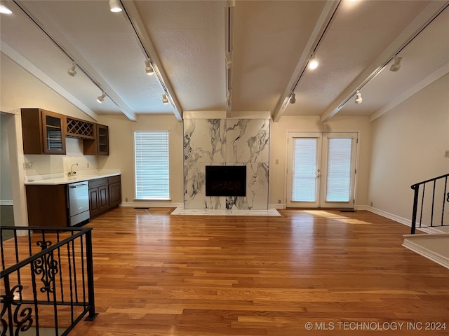 unfurnished living room featuring light hardwood / wood-style flooring, a textured ceiling, a fireplace, and rail lighting