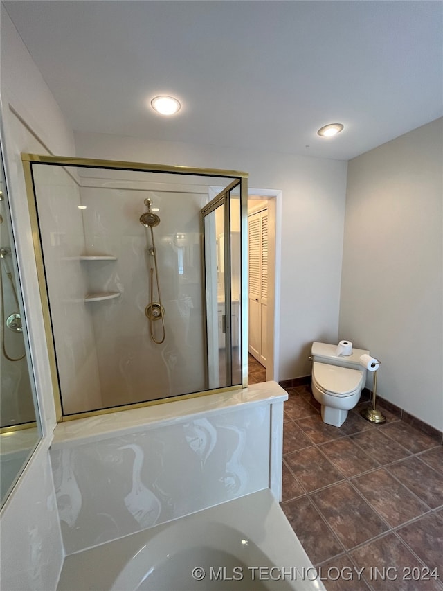 bathroom featuring tile patterned floors, a shower with shower door, and toilet