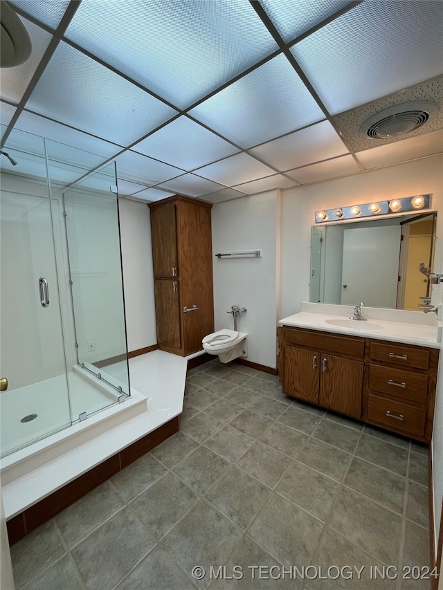 bathroom featuring a paneled ceiling, a bidet, vanity, an enclosed shower, and tile patterned floors