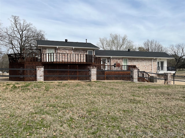 back of house with a deck and a lawn