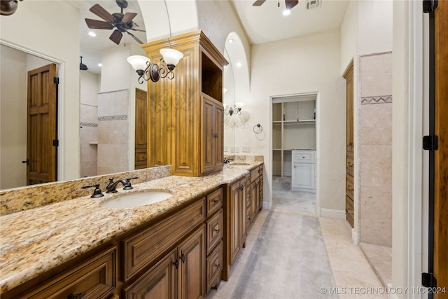 bathroom featuring vanity, tile patterned floors, tiled shower, and ceiling fan