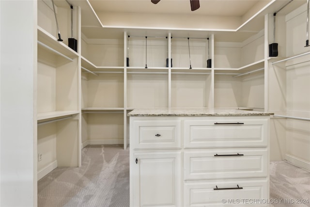 spacious closet with light carpet and ceiling fan