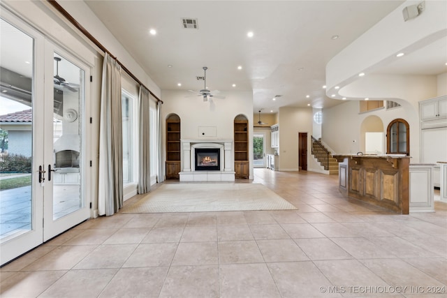 unfurnished living room featuring french doors, ceiling fan, and light tile patterned floors