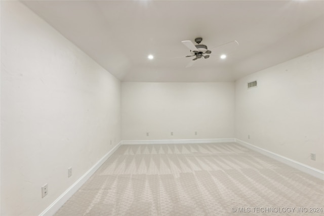 empty room with light carpet, vaulted ceiling, and ceiling fan