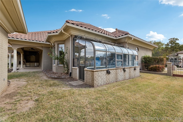 back of house with a patio area, a yard, and a sunroom