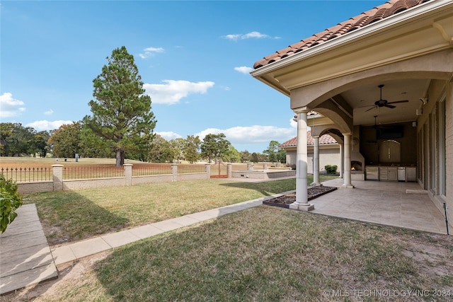 view of yard with a patio area, exterior kitchen, and ceiling fan