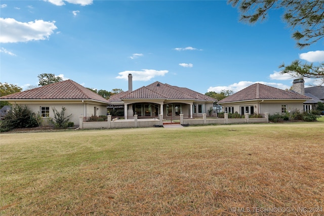 rear view of house featuring a lawn