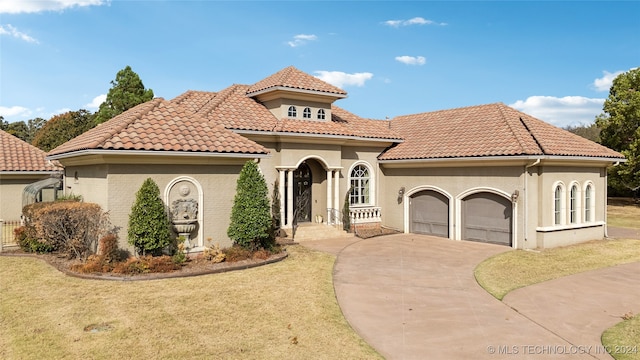 mediterranean / spanish home featuring a front lawn and a garage