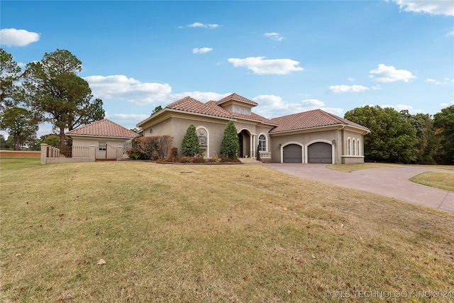 mediterranean / spanish house featuring a garage and a front lawn