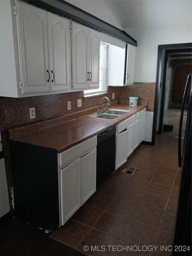 kitchen featuring dark tile patterned floors, black dishwasher, backsplash, sink, and white cabinets