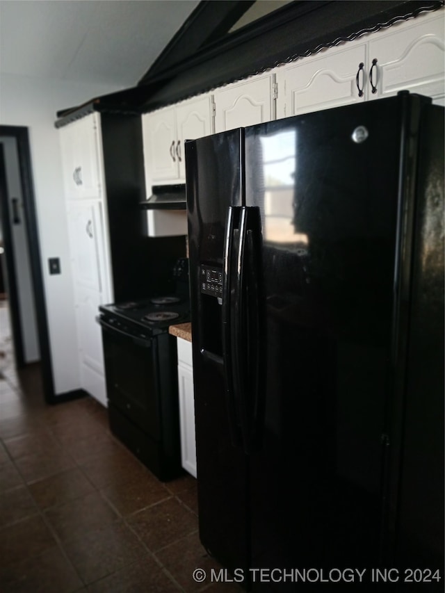 kitchen with black appliances, dark tile patterned floors, and white cabinets