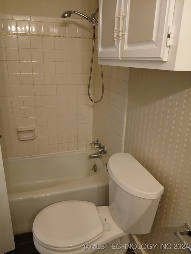 bathroom with toilet and tiled shower / bath