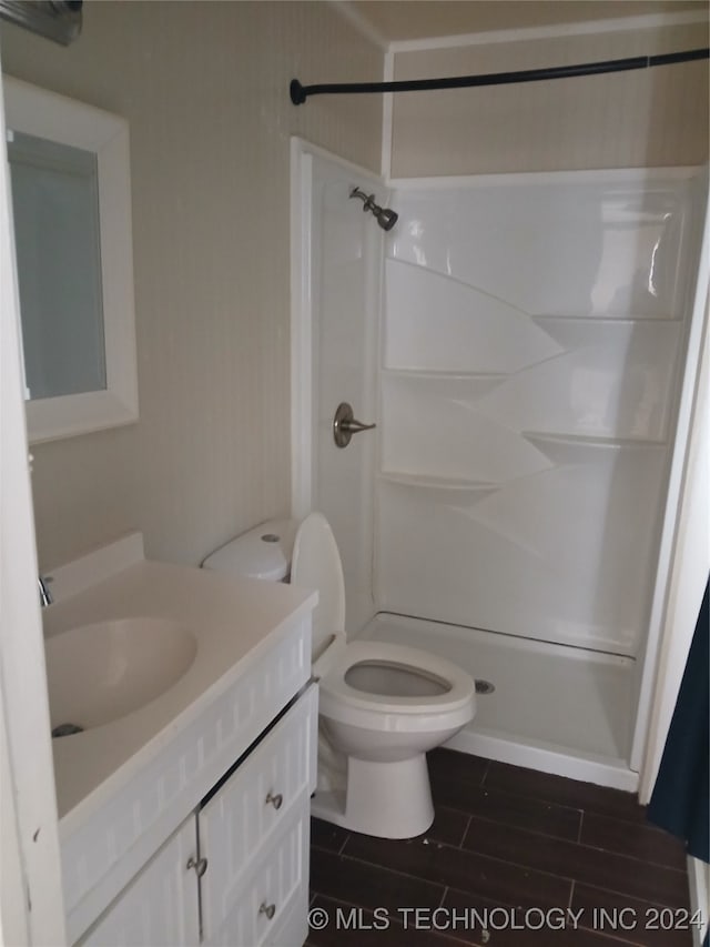 bathroom featuring vanity, walk in shower, toilet, and hardwood / wood-style flooring