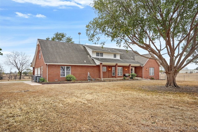 rear view of property featuring a lawn