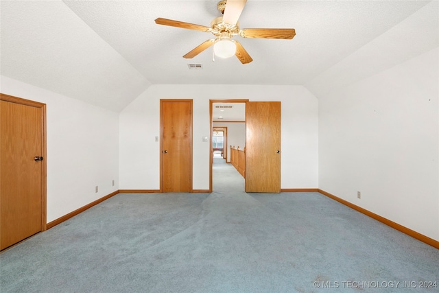 bonus room featuring ceiling fan, a textured ceiling, lofted ceiling, and light colored carpet