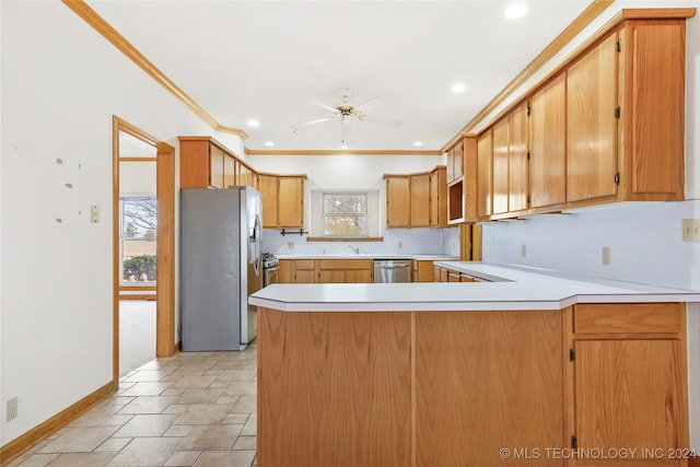 kitchen with crown molding, appliances with stainless steel finishes, kitchen peninsula, and a healthy amount of sunlight