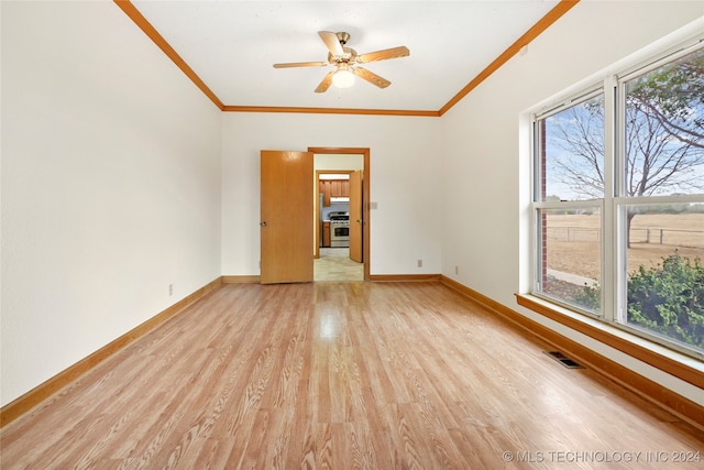 spare room featuring ceiling fan, a healthy amount of sunlight, ornamental molding, and light wood-type flooring