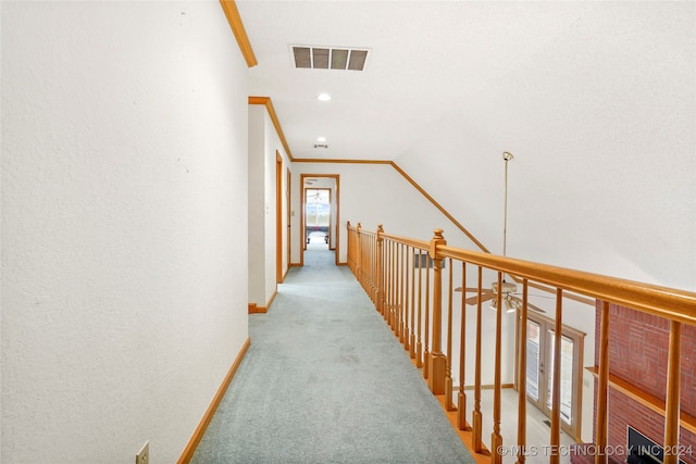 hall featuring ornamental molding, lofted ceiling, and light colored carpet