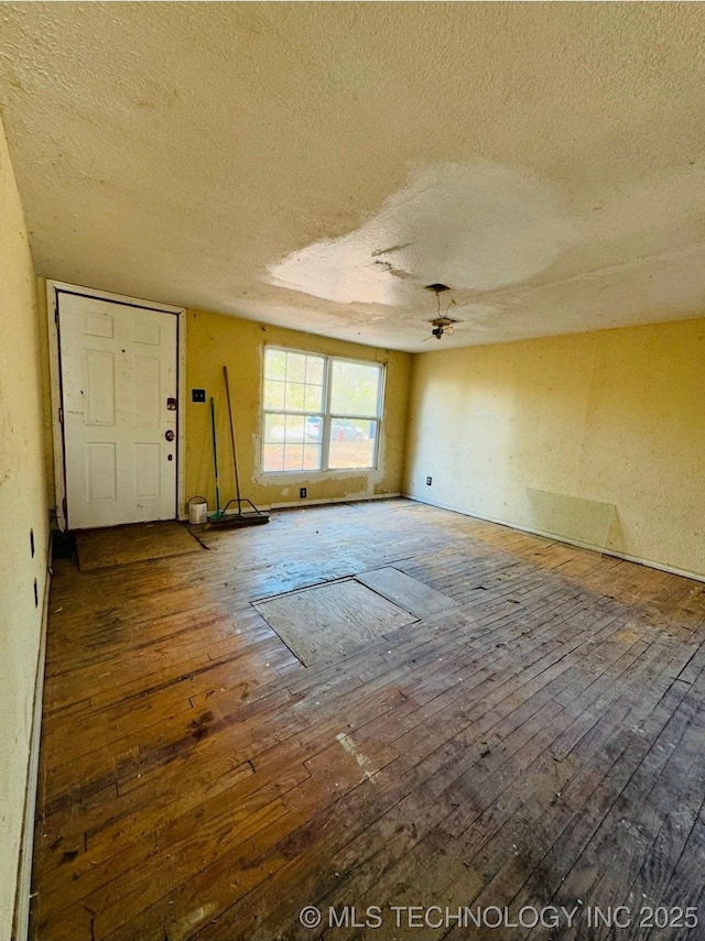 interior space with hardwood / wood-style floors, a textured ceiling, and ceiling fan