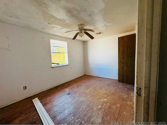 spare room with hardwood / wood-style flooring, a textured ceiling, and ceiling fan