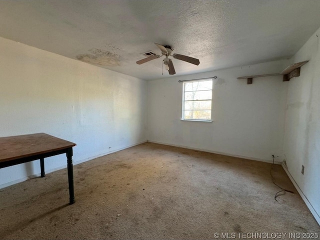 carpeted empty room featuring ceiling fan and a textured ceiling