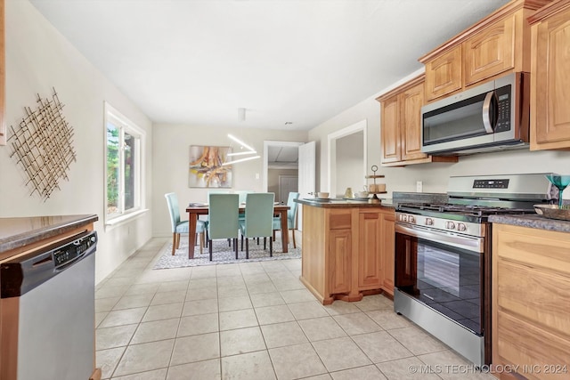 kitchen featuring light tile patterned flooring, kitchen peninsula, and stainless steel appliances