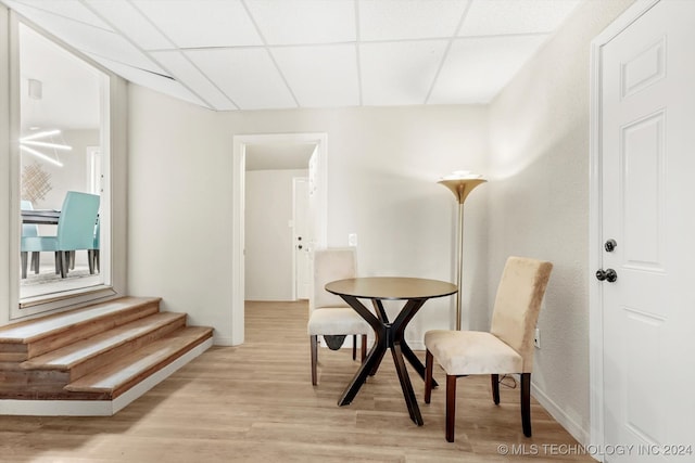 dining area featuring light hardwood / wood-style floors and a paneled ceiling