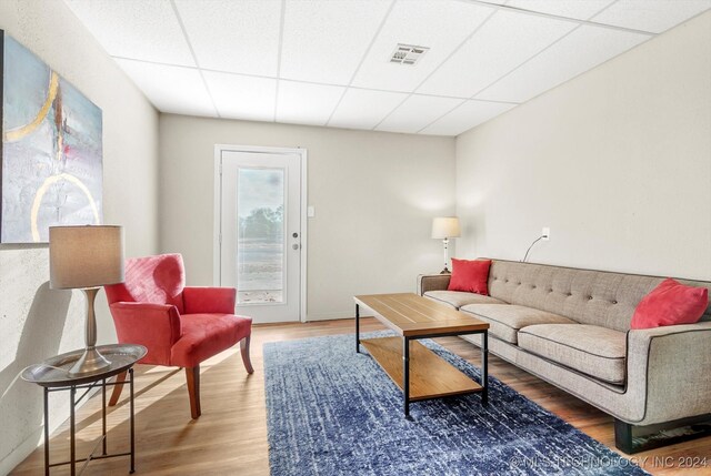 living room with hardwood / wood-style floors and a paneled ceiling