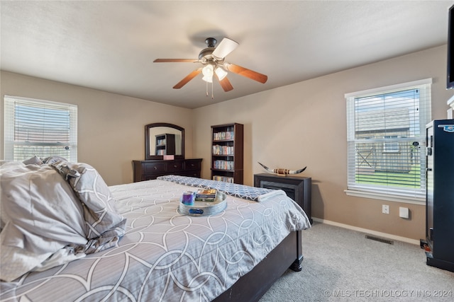 carpeted bedroom with multiple windows and ceiling fan