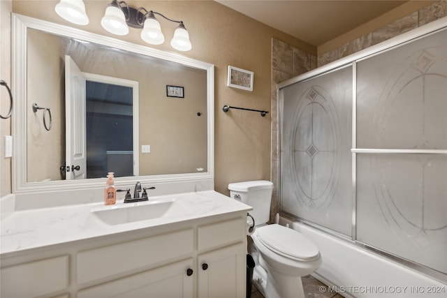 full bathroom with vanity, toilet, and combined bath / shower with glass door